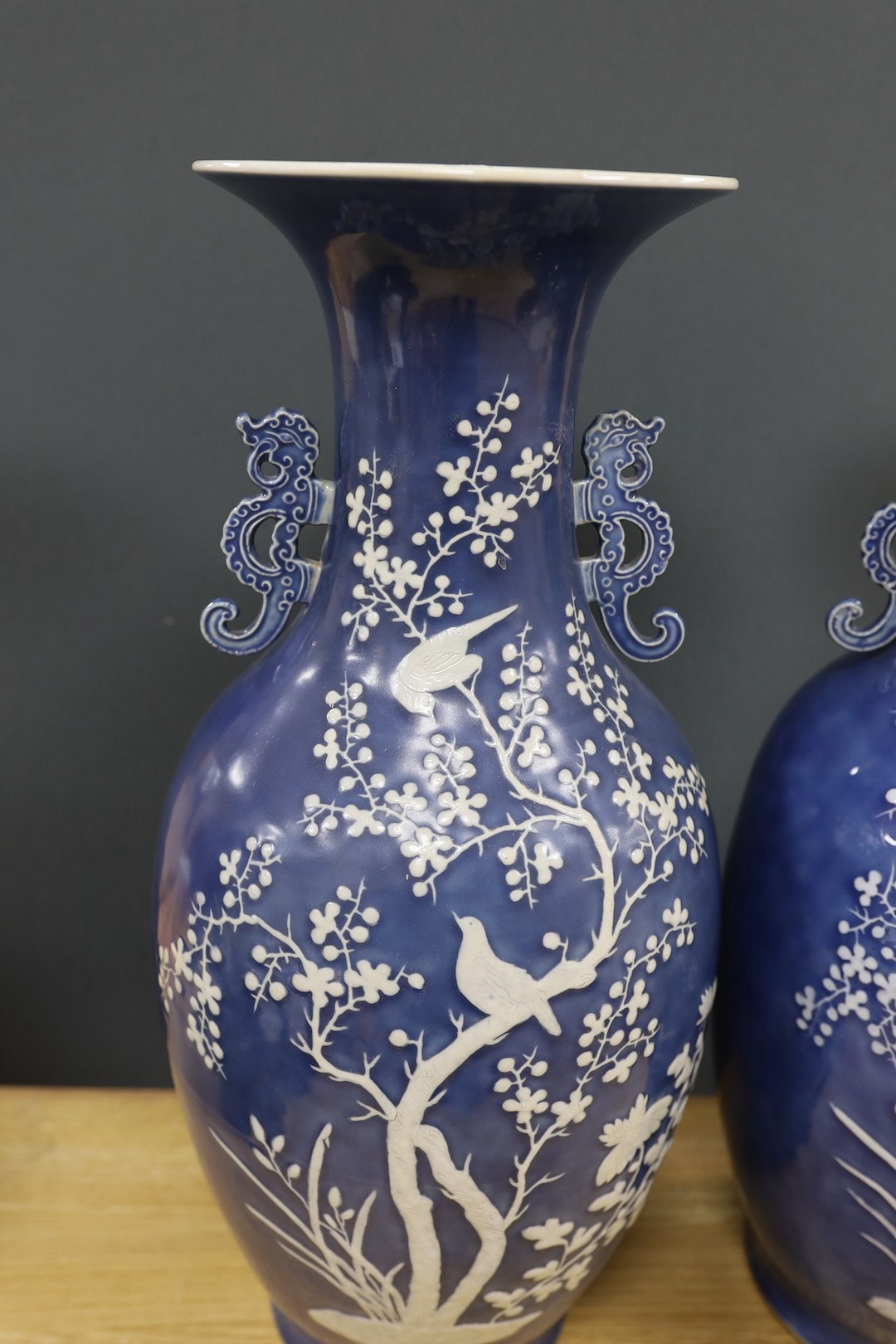 A pair of large 19th century Chinese slip decorated blue ground vases, restored, 59cm